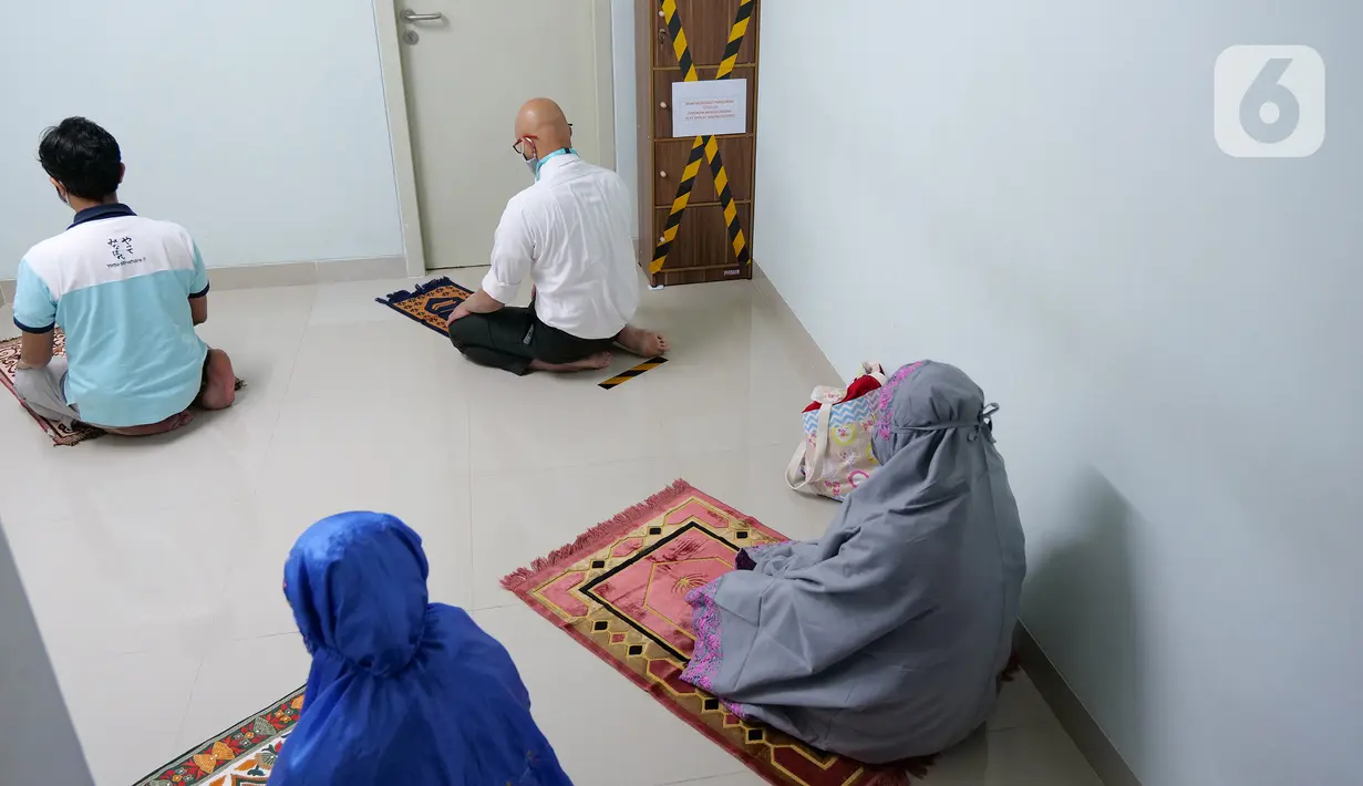 Sejumlah karyawan menjaga jarak saat melaksanakan salat di mushala Suntory Garuda, Jakarta, Senin (8/8/2020). Perusahaan itu menerapkan protokol kesehatan saat hari pertama kerja di masa PSBB transisi yang diterapkan oleh Pemprov DKI Jakarta. (Liputan6.com/Herman Zakharia)