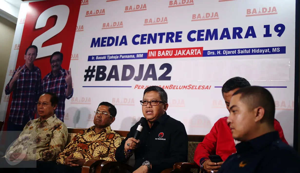 Sekjen PDI Perjuangan Hasto Kristiyanto (tengah) memberikan keterangan di Media Centre Badja, Jakarta, Selasa (18/4). Imbauan netral itu disampaikan terkait pemungutan suara Pilkada DKI Jakarta yang akan dilaksanakan esok hari. (Liputan6.com/Johan Tallo)