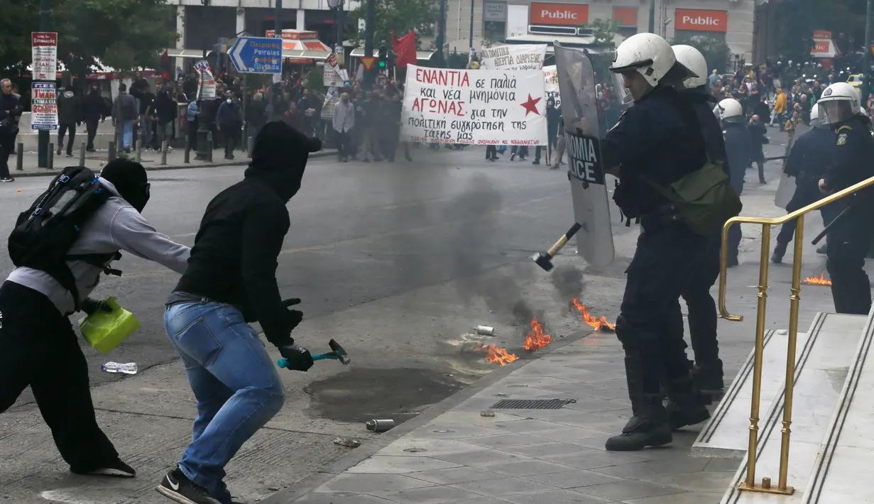 Unjuk rasa pekerja Yunani berujung bentrok dengan polisi di Athena, Rabu (17/5). Para pekerja meninggalkan lapangan kerja untuk melakukan pemogokan umum anti-penghematan. (AP Photo / Thanassis Stavrakis)