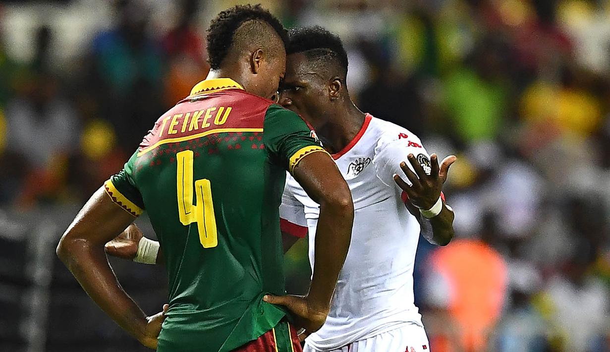 Bek Kamerun, Adolphe Teikeu, bersitegang dengan penyerang Burkina Faso, Banou Teikeu. Pada laga selanjutnya Kamerun akan menghadapi Guinea-Bissau, sementara Burkina Faso akan menantang tuan rumah, Gabon. (AFP/Gabriel Bouys)