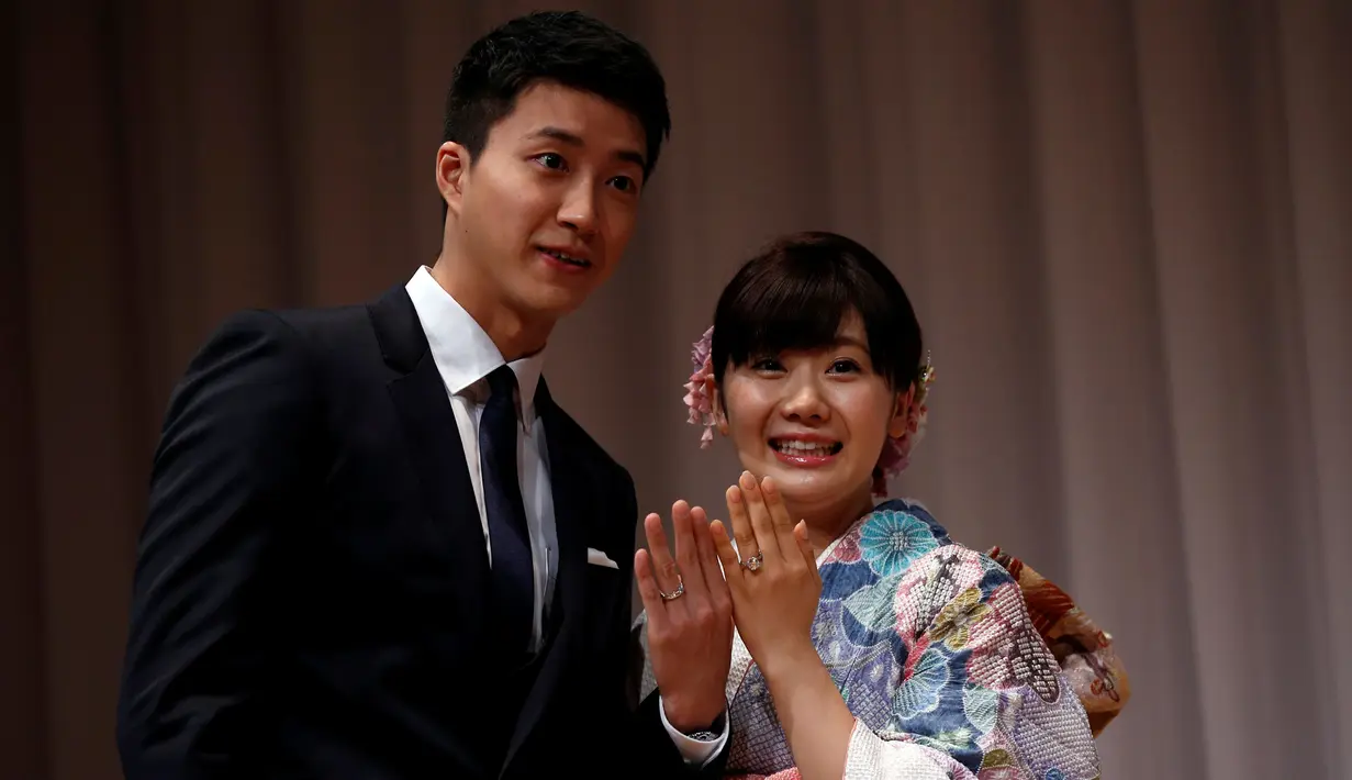 Petenis meja terkenal Jepang, Ai Fukuhara (kanan) dan suaminya Chiang Hung-chieh memperlihatkan cincin kawin mereka kepada wartawan saat jumpa pers di Tokyo, Jepang, (21/9). (REUTERS/Toru Hanai)