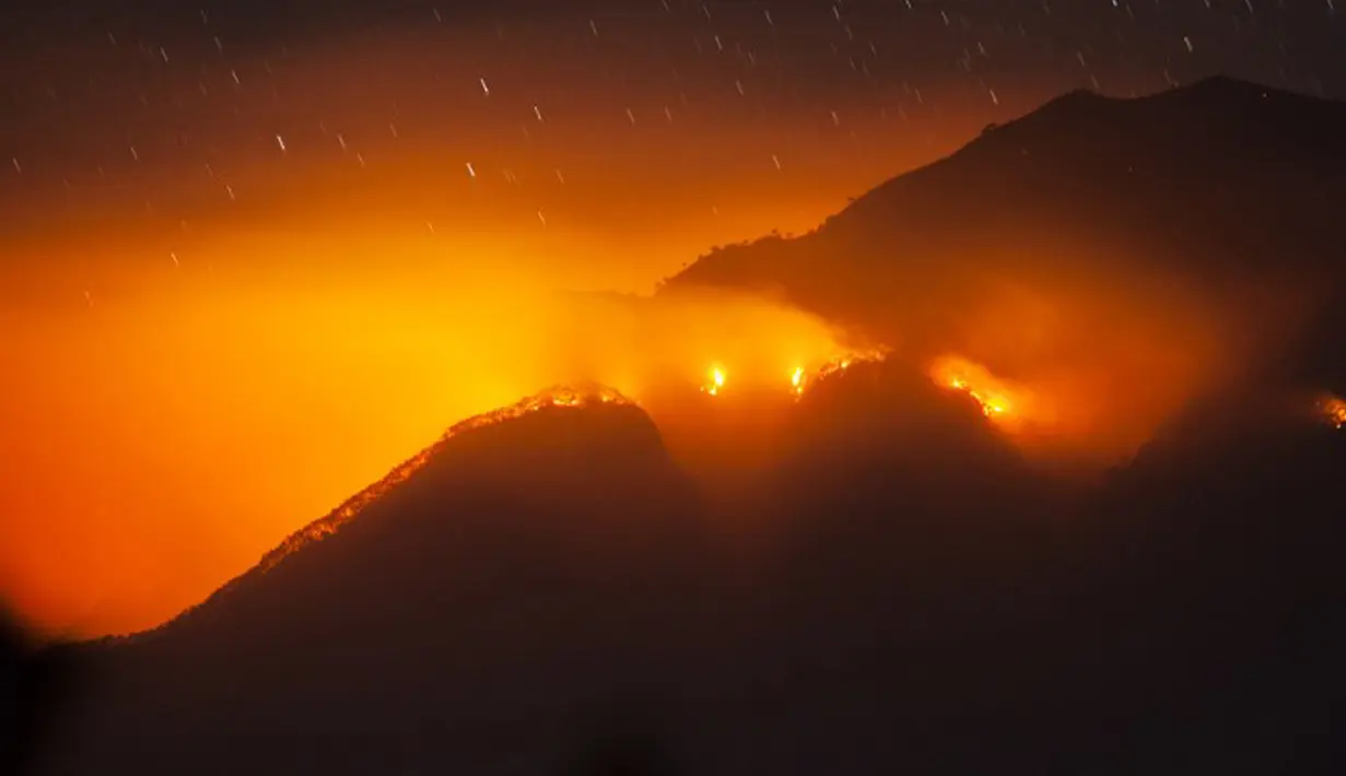 Kobaran api yang melanda lereng Gunung Merbabu terlihat dari Kecamatan Magelang, Jawa Tengah, Jumat (21/8/2015). Kebakaran yang sudah terjadi sejak dua hari yang lalu itu diduga akibat musim kemarau. (AFP PHOTO/SURYO WIBOWO)