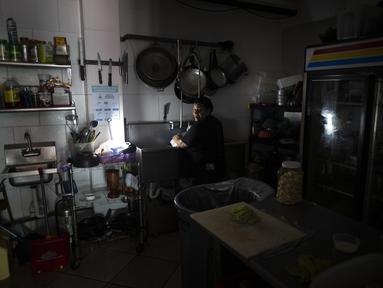 Karyawan Las Palmas Cafe bekerja dengan generator listrik di San Juan, 7 April 2022. Lebih dari satu juta pelanggan di Puerto Rico tetap tanpa listrik setelah kebakaran di pembangkit listrik utama yang menyebabkan pemadaman terbesar sepanjang tahun ini di seluruh wilayah AS. (AP Photo/Carlos Giusti)