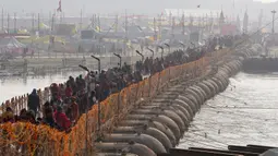 Umat Hindu membawa barang-barang saat tiba untuk berendam di Sangam, pertemuan Sungai Gangga - Sungai Yamuna, saat Festival Magh Mela di Prayagraj, Uttar Pradesh, India, 31 Januari 2023. Ratusan ribu peziarah Hindu diperkirakan akan berenang dalam pertemuan tersebut, berharap bisa menghapus dosa selama festival sebulan penuh. (AP Photo/Rajesh Kumar Singh)