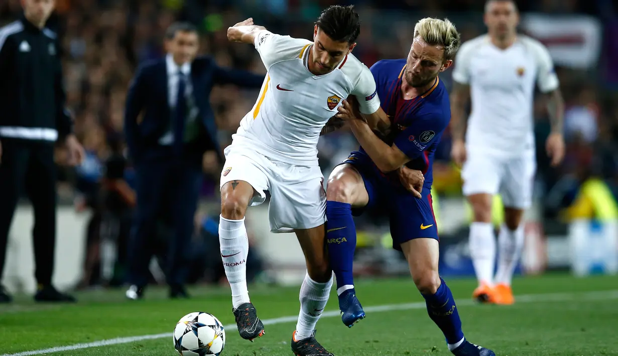 Pemain AS Roma Diego Perotti berebut bola dengan pemain Barcelona Ivan Rakitic saat pertandingan Liga Champions di stadion Camp Nou di Barcelona (4/3). Dua gol Barcelona didapat dari gol bunuh diri pemain AS Roma. (AP Photo / Manu Fernandez)