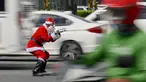 Petugas lalu lintas, Ramiro Hinojas mengenakan kostum sinterklas sambil mengarahkan kendaraan di sepanjang Macapagal Avenue di Pasay, Metro Manila, Filipina pada 28 November 2023. (JAM STA ROSA/AFP)