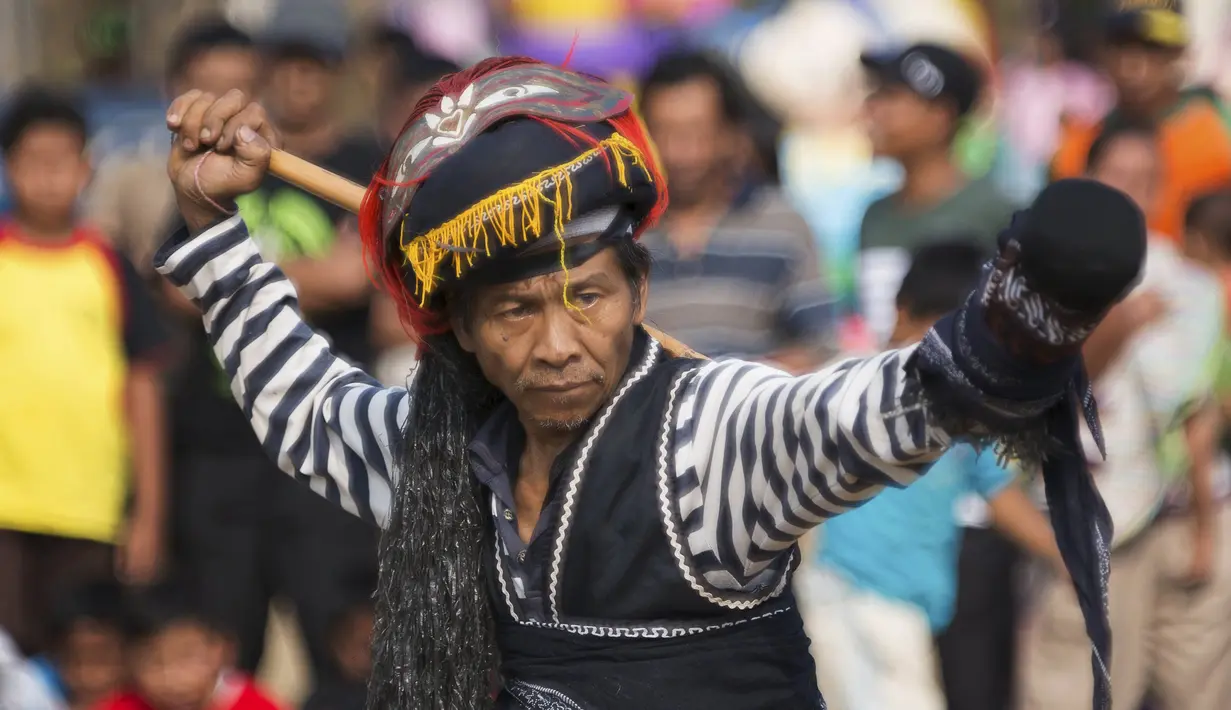 Seorang pria berpakaian seperti prajurit tradisional melakukan ritual 'Ujungan' atau tari sabet di Desa Karang Jati, Banjarnegara, Jateng, Jumat (23/10). Pertarungan rotan antara dua orang ini merupakan ritual untuk meminta hujan. (REUTERS/Nicholas Owen)
