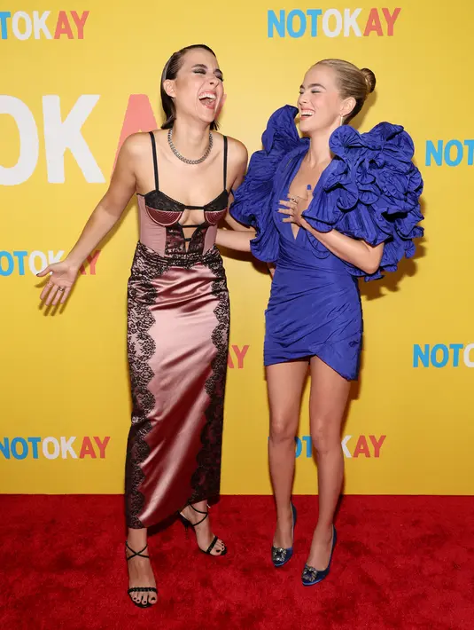 Zoey Deutch dan Quinn Shephard tertawa di karpet merah saat menghadiri pemutaran perdana "Not Okay" di Angelika Film Center di New York (28/7/2022). Film ini bercerita tentang seorang influencer muda ambisius Danni Sanders, diperankan oleh Deutch, yang ingin mendapatkan teman, pengikut, dan ketenaran. (Dia Dipasupil/Getty Images/AFP)