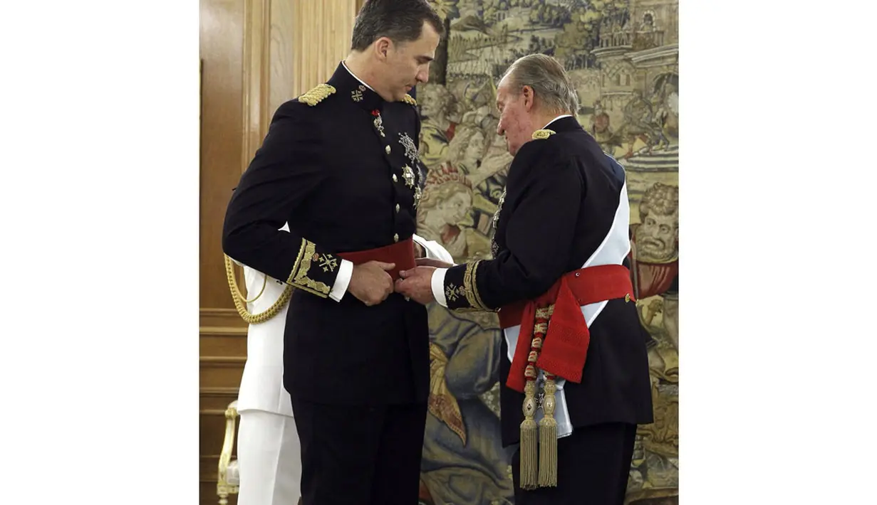 Juan Carlos (kanan) menyematkan selempang kehormatan kepada Pangeran Felipe VI dalam upacara pelantikan Raja baru Spanyol di La Zarzuela Palace, Madrid, Spanyol, (19/6/2014). (REUTERS/Juan Carlos Cardenas)