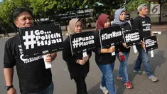 Sejumlah aktivis Walhi berjalan mengampanyekan pengurangan penggunaan plastik di kawasan Bundaran Hotel Indonesia, Jakarta, Minggu (6/3). Mereka mengajak masyarakat mengurangi penggunaan plastik. (Liputan6.com/Helmi Fithriansyah)