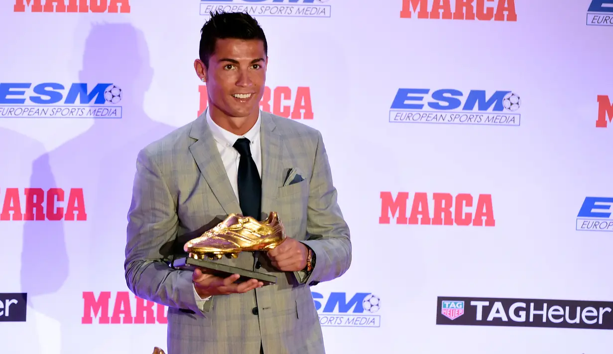 Penyerang Real Madrid, Cristiano Ronaldo berpose dengan sepatu emas keempatnya di Madrid, Spanyol, Selasa (13/10). Ronaldo kembali menerima Golden Boot dan merupakan gelar keempat bagi dirinya setelah mencetak 48 gol. (AFP PHOTO/JAVIER Soriano)