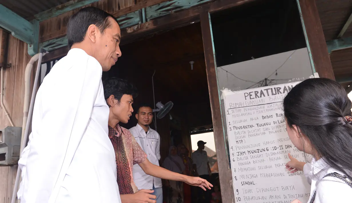 Presiden Jokowi didampingi Menko PMK Puan Maharani (kanan) mendengarkan penjelasan petugas saat meninjau rumah evakuasi balita yang terkena dampak kabut asap di kawasan 5 Ulu, Palembang, Sumsel, Jumat (30/10). (Laily Rachev_Setpres)