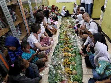 Sejumlah anak yatim, kaum dhuafa bersama lima WNA menikmati makanan nasi liwet sambil lesehan di Rumah Amalia, Ciledug, Kota Tangerang, Sabtu (3/3). Lima WNA itu tergabung dalam komunitas couchsurfing Indonesia. (Liputan6.com/Fery Pradolo)