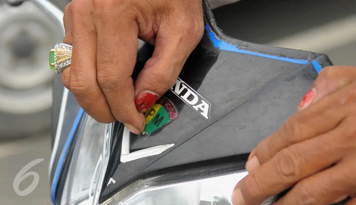 Sebuah stiker berlambang Polisi Militer dicopot saat Operasi Gaktib Garnisun Tetap 1 di kawasan Pesing, Jakarta,  Kamis, (11/2/2016). Razia ini yang dilakukan untuk menertibkan aksesoris berlambangkan TNI dan Polri. (Liputan6.com/Faisal R Syam)