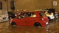 Kendaraan terjebak kemacetan di tengah banjir yang melanda terowongan (underpass) Cawang, Jalan MT Haryono, Jakarta, Selasa (12/12). Hujan deras yang mengguyur sebagian Jakarta mengakibatkan banjir di kawasan ini. (Liputan6.com/Herman Zakharia)