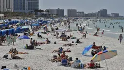 Pengunjung menikmati Clearwater Beach di Florida, Amerika Serikat, Rabu (18/3/2020). Para pengunjung diminta menjaga jarak satu sama lain untuk mengurangi risiko penyebaran virus corona COVID-19. (AP Photo/Chris O'Meara)