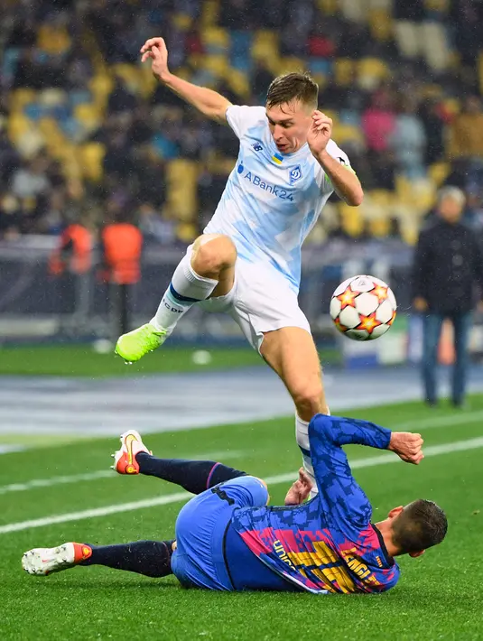 Gelandang Dynamo Kiev Serhiy Sydorchuk berebut bola dengan bek Barcelona Clement Lenglet pada Matchday 4 Liga Champions di NSK Olimpiyskiy, Rabu (3/11/2021) dini hari WIB.  Barcelona menang tipis 1-0 saat bertamu ke markas Dynamo Kiev. (Sergei SUPINSKY / AFP)