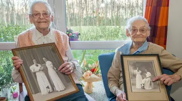 Paulette Olivier (kiri) dan Simone Thiot memperlihatkan foto semasa muda di Ephad "Les Bois Blancs", Prancis (13/2). Paulette dan Simone lahir pada 30 Januari 1912 di Limeray, beberapa kilometer dari Amboise. (AFP PHOTO/GUILLAUME souvent)