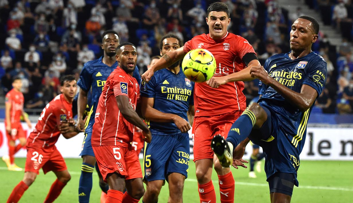 Bek Lyon, Rafael Peirera da Silva, berebut bola dengan bek Nimes, Anthony Briancon, pada laga lanjutan Liga Prancis di Stadion Groupama, Sabtu (19/9/2020) dini hari WIB. Lyon bermain imbang 0-0 atas Nimes. (AFP/Jean-Philippe Ksiazek)