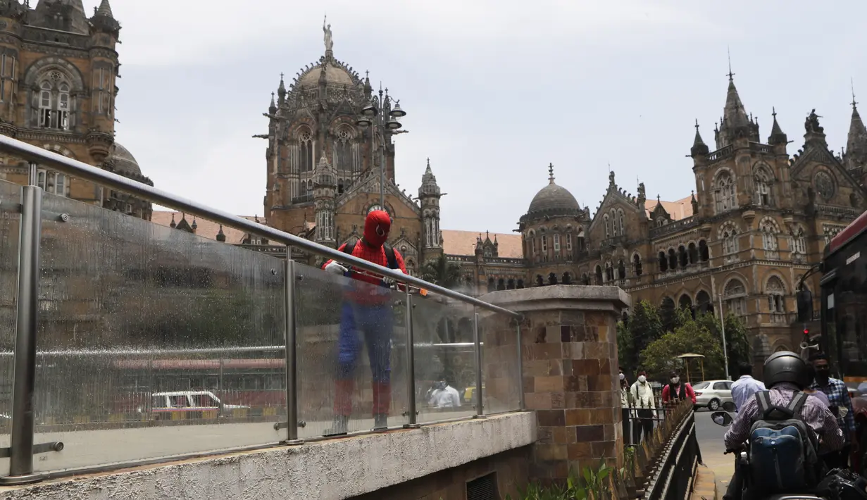 Pekerja sosial India Ashok Kurmi berpakaian seperti Spider Man mendesinfeksi daerah di sekitar stasiun kereta Chhatrapati Shivaji Maharaj selama lockdown yang diberlakukan di Mumbai, Rabu (21/4/2021). Kegiatan tersebut dilakukan untuk mengekang penyebaran COVID-19 di Mumbai. (AP Photo/Rajanish Kakad