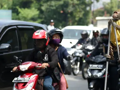 Seekor monyet melakukan atraksi di jalur Pantura Brebes, Jawa Tengah, Kamis (22/6). Kehadiran atraksi topeng monyet ini menjadi salah satu hiburan para pemudik yang hendak mudik ke kampung halamannya. (Liputan6.com/Gempur M Surya)