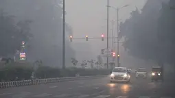 Kendaraan melintas saat asap tebal menyelimuti kota New Delhi, India (20/10). Polusi udara yang parah tersebut dikarenakan banyaknya kembang api yang dinyalakan selama Festival Diwali. (AFP Photo/Dominique Faget)