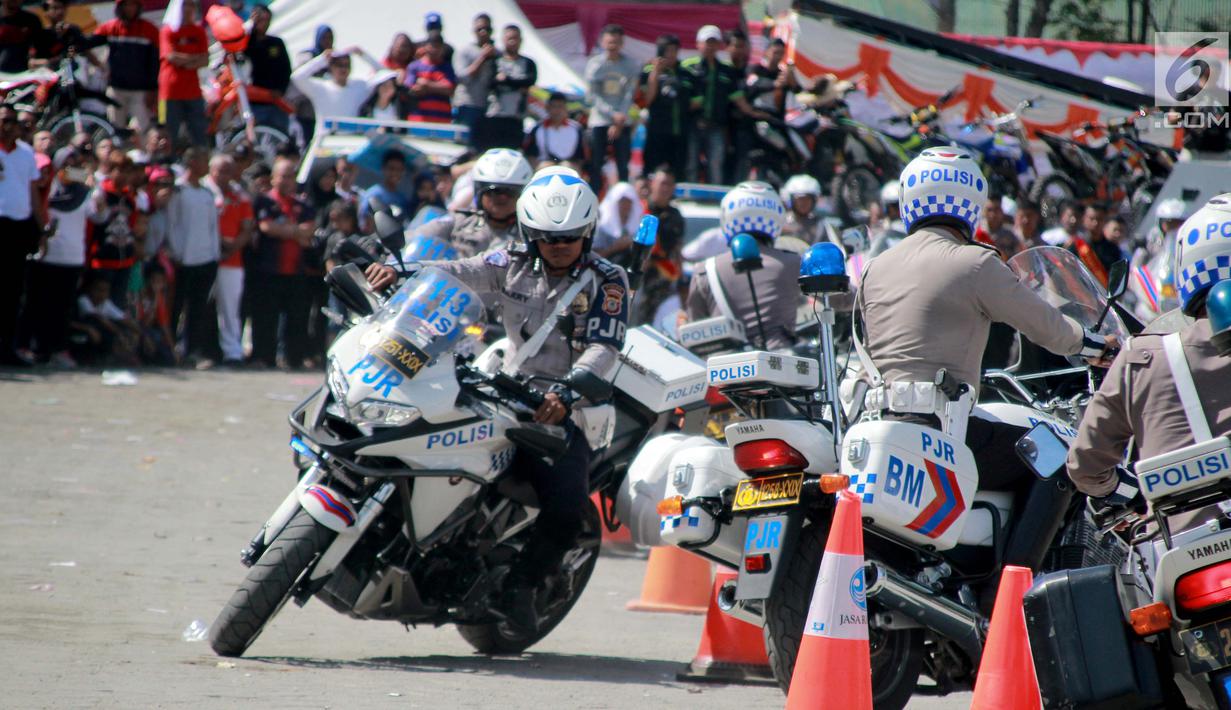 Sejumlah anggota Satlantas Polda Gorontalo beratraksi menggunakan motor gede selama Road Safety Festiva Millenial Gorontalo di Lapangan Taruna Remaja Kota Gorontalo, Minggu (10/2). (Liputan6.com/Rahmad Arfandi Ibrahim)