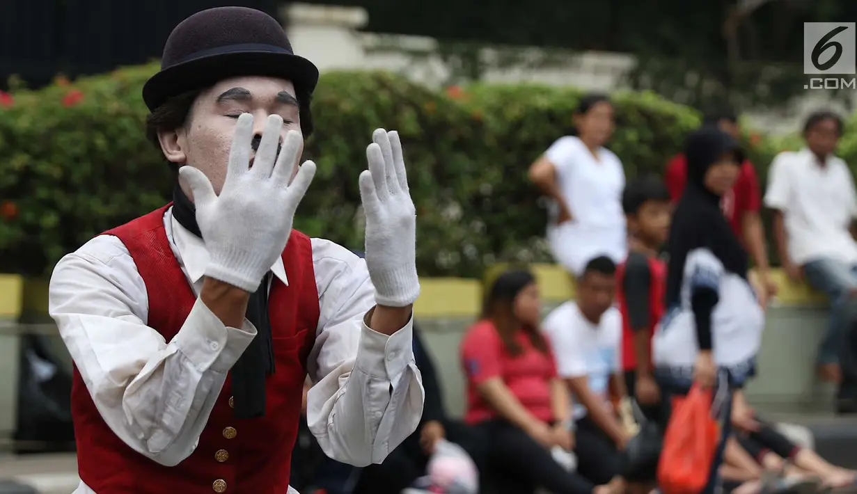 Seniman pantomim tampil menghibur pengunjung car free day di Jakarta, Minggu (1/7). Aksi tersebut dilakukan guna mengumpulkan biaya yang akan digunakan untuk menikah. (Liputan6.com/Immanuel Antonius)