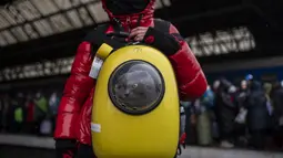 Seorang gadis Ukraina dan kucingnya menunggu di peron stasiun kereta api Lviv, di Lviv, Ukrainan barat pada 27 Februari 2022. Dalam eksodus lebih dari 2,5 juta orang yang melarikan diri dari invasi Rusia, terdapat hewan peliharaan yang tidak dapat ditinggalkan. (AP Photo/Bernat Armangue)
