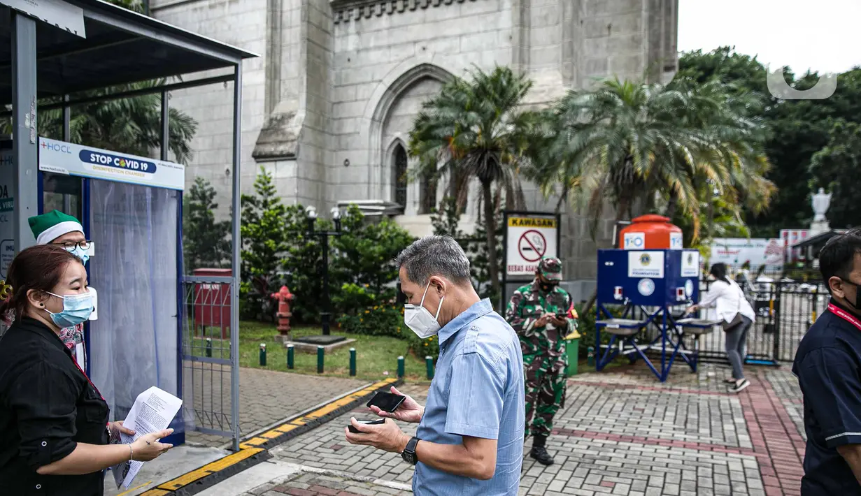Para Jemaat memperlihatkan bukti pendaftaran untuk mengikuti ibadah di Gereja Katedral, Jakarta, Kamis (24/12/2020). Aturan ditetapkan oleh Keuskupan Agung Jakarta agar pelaksanaan Natal 2020 tetap melaksanakan protokol kesehatan. (Liputan6.com/Faizal Fanani)