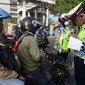 Polisi menindak pengendara sepeda motor yang melanggar aturan lalu lintas di Jalan Pasar Rumput, Manggarai, Jakarta, Selasa (21/7/2020). Polisi akan menggelar Operasi Patuh Jaya 2020 pada 23 Juli sampai 5 Agustus 2020 di seluruh Polda se-Indonesia. (merdeka.com/Imam Buhori)