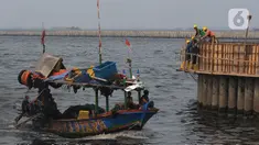 Pekerja menyelesaikan proyek tanggul pengaman pantai Kampung Nelayan Cilincing, Jakarta, Jumat (10/11/2023). (merdeka.com/Imam Buhori)