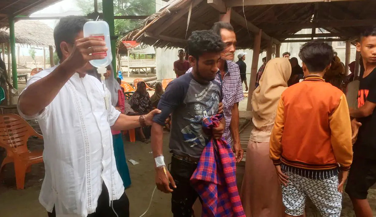 Petugas medis memberi perawatan kepada pengungsi Rohingya yang terdampar di Bireuen, Aceh, Jumat (20/4). Pengungsi yang diselamatkan terdiri atas 43 laki-laki, 25 perempuan, dan 8 anak-anak. (AP Photo / Zik Maulana)