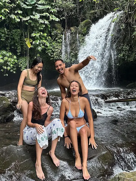 Bermain ke air terjun, Yuki mengenakan spaghetti strap hitam dipadukan celana panjang putih. Lalu sang adik tampil dengan swim wear hijau army. [@yukikt]