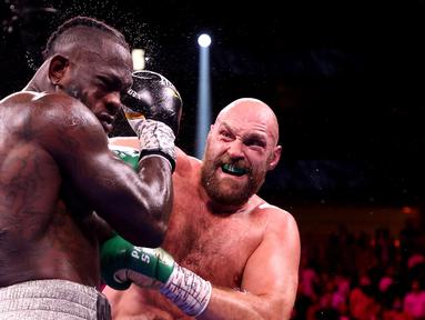 Tyson Fury berhasil mempertahankan gelar juara kelas verat versi WBC. Menghadapi Deontay Wilder dalam duel trilogi di MGM Arena, Minggu pagi WIB (10/10/2021), Fury sukses menang KO. (AFP via Getty Images/Al Bello)