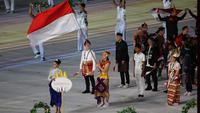 Atlet renang putri, Flairene Candrea Wonomiharjo tampil sebagai pembawa bendera Kontingen Indonesia dalam upacara pembukaan SEA Games 2023 di Morodok Techo Stadium, Phnom Penh, Kamboja, Jumat (5/5/2023) malam WIB. Peraih medali emas pada SEA Games 2021 di Vietnam itu melangkah pasti memimpin Kontingen Indonesia dalam defile negara peserta. (Bola.com/Abdul Aziz)