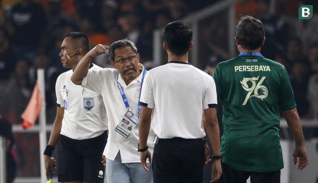 Pelatih Persebaya Surabaya, Aji Santoso (dua kiri), memberikan isyarat kepada salah satu asisten wasit bahwasannya bola umpan pemain Persebaya dibuang keluar oleh pemain Persija Jakarta. (Bola.com/Ikhwan Yanuar)