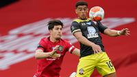 Pemain Southampton, Che Adams berusaha mengontrol bola dari kawalan bek Manchester United, Harry Maguire pada pertandingan lanjutan Liga Inggris di Old Trafford di Manchester, Inggris (13/7/2020). MU bermain imbang 2-2 atas  Southampton. (AP Photo/Dave Thompson,Pool)