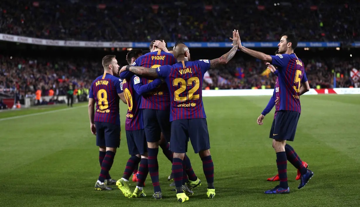 Para pemain Barcelona merayakan gol yang dicetak oleh Gerard Pique ke gawang Rayo Vallecano pada laga La Liga di Stadion Camp Nou, Sabtu (9/3). Barcelona menang 3-1 atas Rayo Vallecano. (AP/Manu Fernandez)