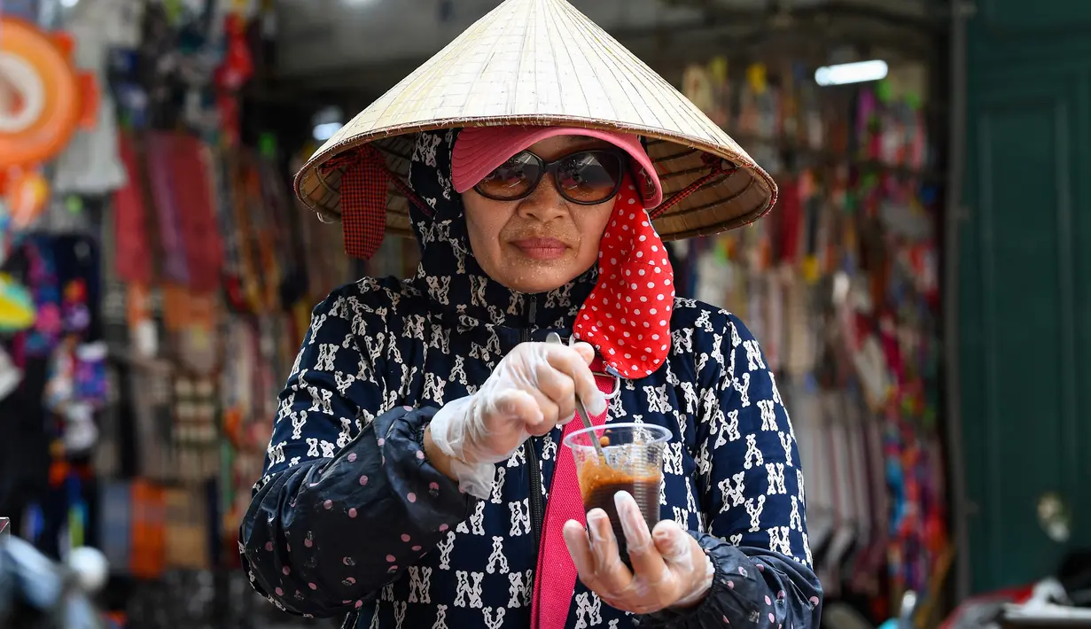 Tapi bagi pedagang yang mata pencahariannya diperoleh dari jalanan, nasihat itu mustahil untuk diikuti. (Photo by Nhac NGUYEN / AFP)
