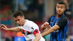 Pemain Inter Milan, Rafinha berebut bola dengan pemain Cagliari, Andrea Cossu pada laga pekan ke-33 Serie A, di Giuseppe Meazza, Selasa (17/4). Menjamu Cagliari, Inter Milan memetik kemenangan meyakinkan dengan skor 4-0. (AP/Antonio Calanni)