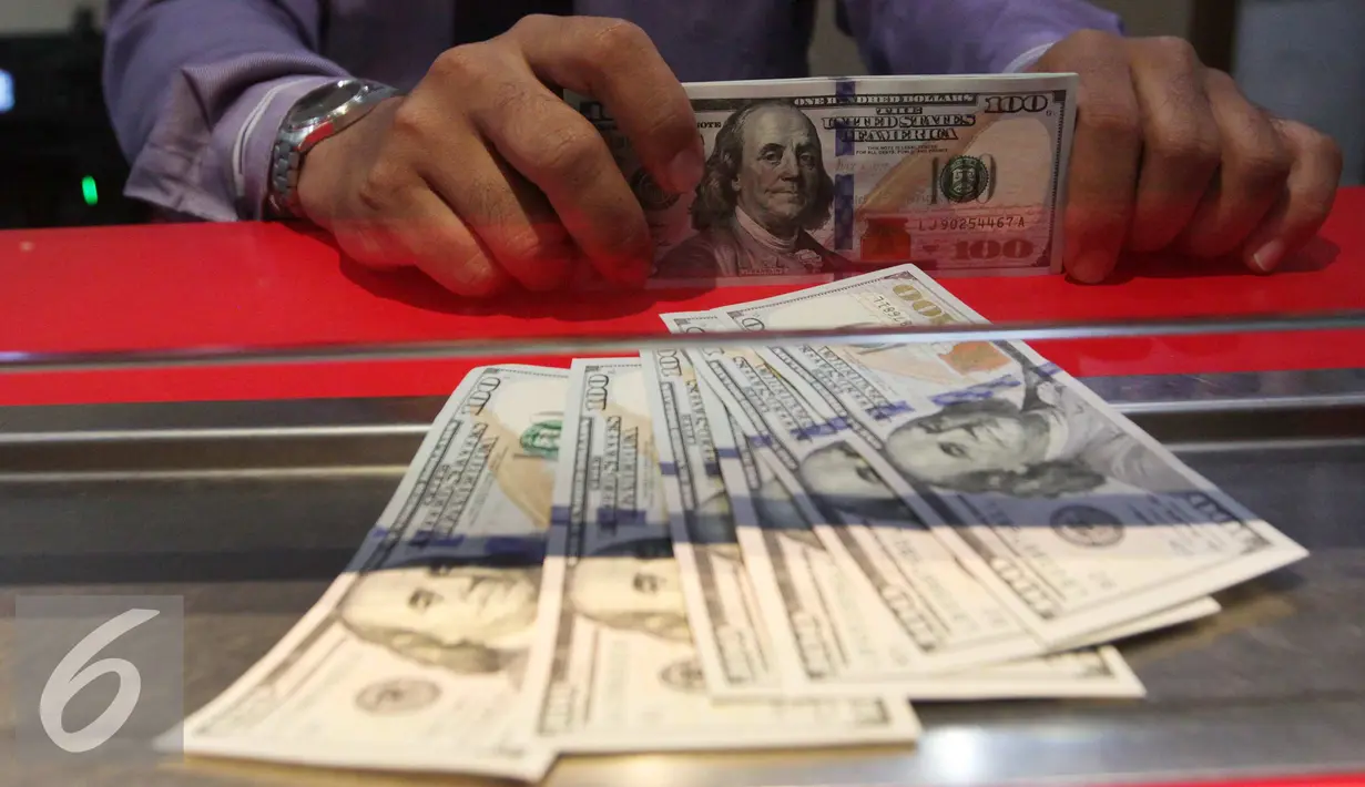 Petugas memperlihatkan uang pecahan US$100 dan rupiah di pusat penukaran uang, Jakarta, Rabu (23/9/2015). Pada perdagangan pagi hingga siang ini, rupiah terus bergerak di kisaran 14.577 per dolar AS hingga 14.658 per dolar. (Liputan6.com/Angga Yuniar)