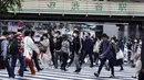 Orang-orang mengenakan masker berjalan melintasi penyeberangan pejalan kaki pada awal liburan "Minggu Emas" Jepang di distrik Shibuya, Tokyo, Kamis (29/4/2021). Golden Week atau Minggu Emas adalah periode di akhir bulan April sampai minggu pertama bulan Mei. (AP Photo/Eugene Hoshiko)