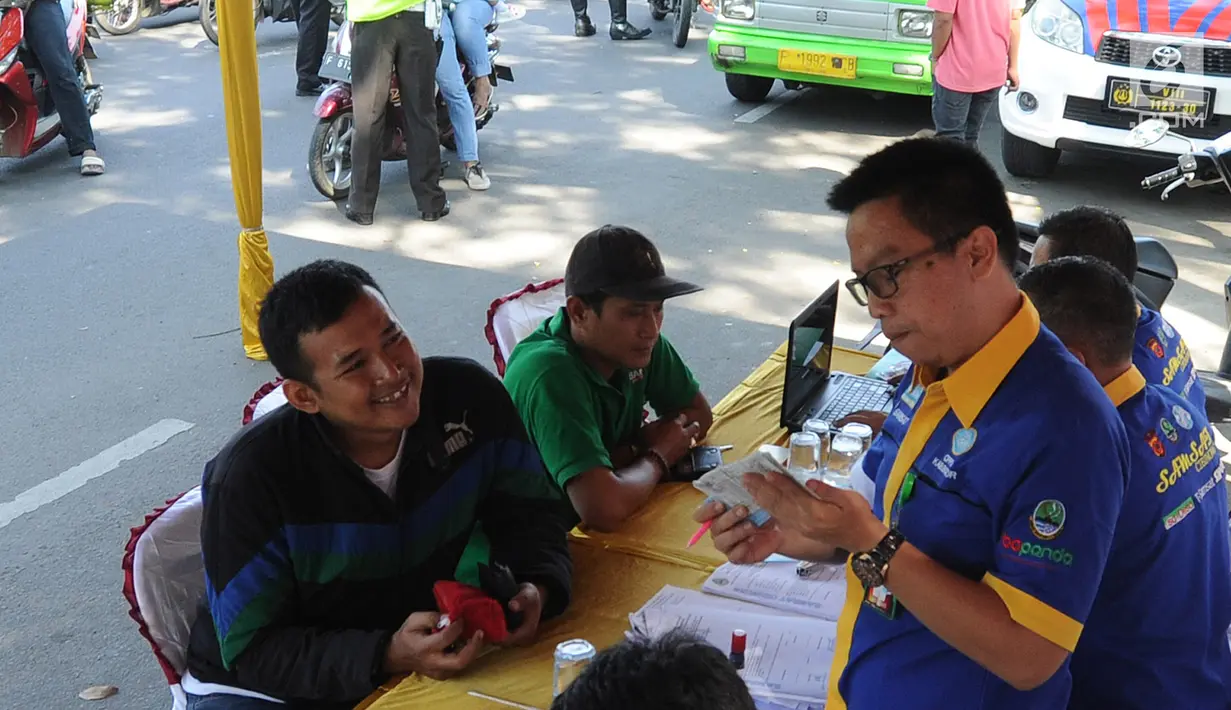Petugas memeriksa pajak STNK saat melakukan razia gabungan di kawasan Naggewer, Bogor, Selasa (18/9). Razia yang melibatkan unsur POLRI, POM, Dishub dan Dispenda ini menyasar pemilik kendaraan yang belum membayar pajak kendaraan. (Merdeka.com/Arie Basuki)