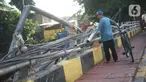Warga berjalan di samping pagar jembatan yang rusak di kawasan Bukit Duri, Jakarta, Jumat (21/2/2020). Pagar yang rusak akibat penanganan sampah banjir tersebut hingga kini belum juga diperbaiki. (Liputan6.com/Immanuel Antonius)