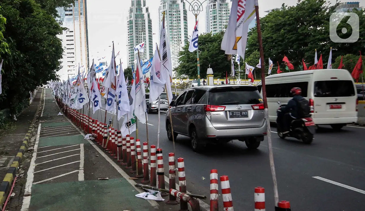 Pemasangan bendera parpol di jalur sepeda sangat membahayakan pengendara yang melintas. (Liputan6.com/Angga Yuniar)