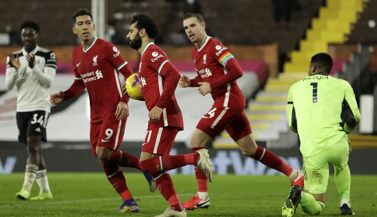 Striker Liverpool, Mohamed Salah (tengah), melakukan selebrasi usai mencetak gol ke gawang Fulham melalui eksekusi penalti dalam laga lanjutan Liga Inggris 2020/21 pekan ke-12 di Craven Cottage, Minggu (13/12/2020). Liverpool bermain imbang 1-1 dengan Fulham. (AFP/Matt Dunham/Pool)