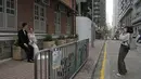 Fotografer yang mengenakan masker mengambil foto pernikahan pasangan di sebuah jalan di Hong Kong, Minggu (13/3/2022). Pemimpin Hong Kong Carrie Lam mengatakan infeksi Covid-19 di kota itu belum melewati puncaknya meskipun jumlah kasus harian baru-baru ini sedikit menurun. (AP Photo/Kin Cheung)