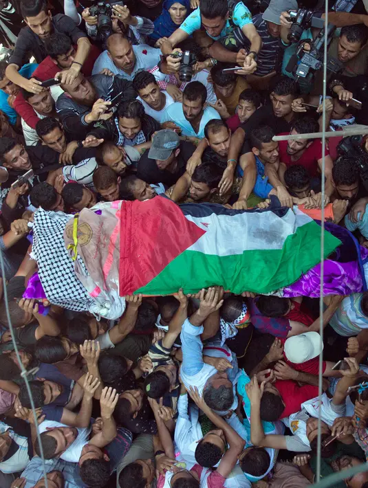 Pelayat membawa jasad perawat Palestina, Razan Najjar saat pemakamannya di Kota Khan Younis, Jalur Gaza Selatan, Sabtu (2/6). Peluru tajam yang ditembakkan tentara Israel menembus punggung Razan dan merangsek ke jantungnya. (AP Photo/Khalil Hamra)
