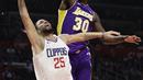 Pemain Clippers, Austin Rivers (bawah) melepaskan tembakan saat diadang pemain Lakers, Julius Randle pada laga NBA basketball games di Staples Center, Los Angeles, California, (27/11/2017). Clippers menang atas Lakers 120-115. (AP/Jae C. Hong)